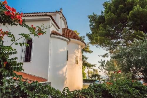 a white building with a window and trees at Bohemia Luxury Living in Hanioti