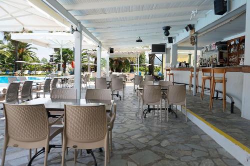 a restaurant with tables and chairs and a pool at Elizabeth in Roda