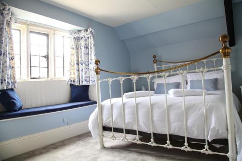 a bedroom with blue walls and a bed and a window at Mortons Manor in Corfe Castle