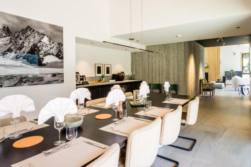 a dining room with a table and white chairs at Le Chalet Mont Blanc in Les Houches