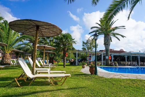 a group of chairs and umbrellas next to a pool at Elizabeth in Roda