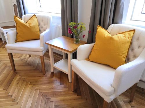 a living room with two chairs and a table with yellow pillows at Ferienhof Trapp in Ellringen