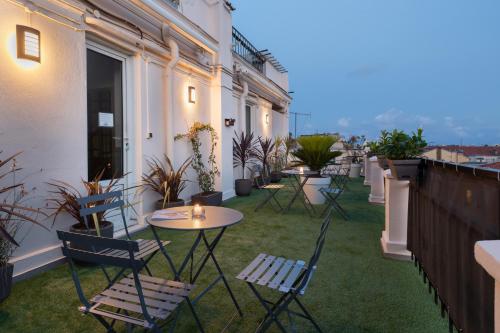 a patio with chairs and tables on a balcony at Hôtel Byakko Nice in Nice