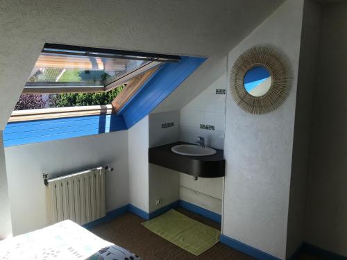 ein Badezimmer mit einem Waschbecken, einem Fenster und einem Spiegel in der Unterkunft Grand et Charmant 3 pièces Breton Saint Brieuc Centre in Saint-Brieuc