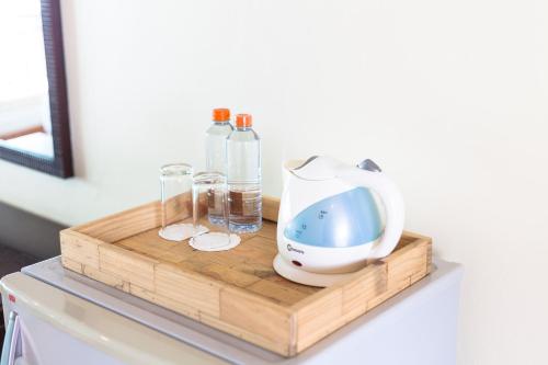 a cutting board with a hair dryer and bottles on a table at Seaside Jomtien Beach Pattaya in Jomtien Beach