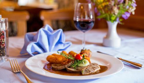 a plate of food on a table with a glass of wine at Appartement- und Wellnesshotel Charlotte - 3 Sterne Superior in Seefeld in Tirol
