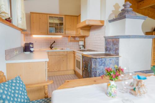 a kitchen with a stove and a table at Appartement- und Wellnesshotel Charlotte - 3 Sterne Superior in Seefeld in Tirol