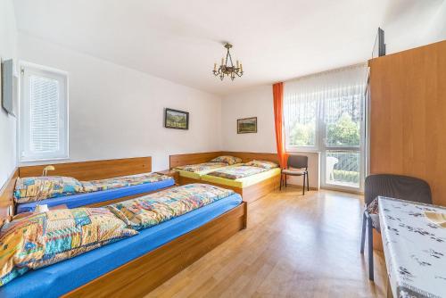 a bedroom with two beds and a table at Pokoje gościnne Neptun in Ostrowo