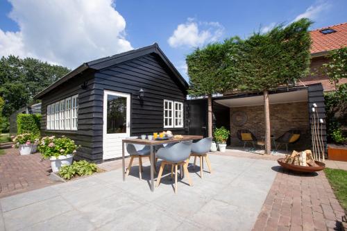 a black shed with a table and chairs on a patio at Tukken op de Tol in Velp