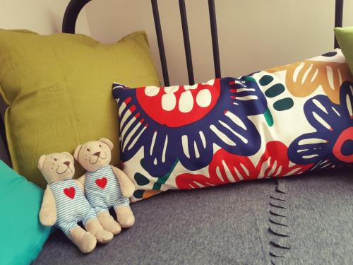 two stuffed teddy bears sitting on a bed with pillows at Apartmány na náměstí in Šumperk