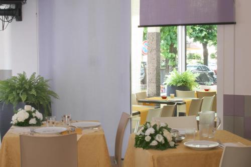 ベッラーリア・イジェア・マリーナにあるHotel Villa Rossiのダイニングルーム(花のテーブルと椅子付)