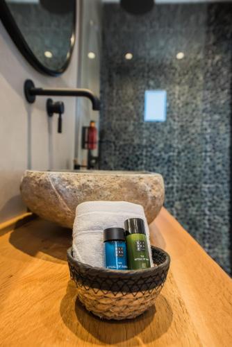 a basket with two bottles ofodorizers on a table in a bathroom at Bohemia Luxury Living in Hanioti