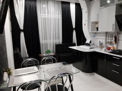 a kitchen with white counters and black curtains and chairs at Маршала Малиновського 18 б 12 Жемчужина квартира in Odesa