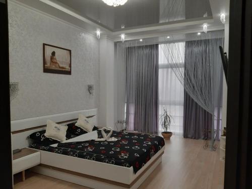 a bedroom with a bed and a large window at Маршала Малиновського 18 б 12 Жемчужина квартира in Odesa