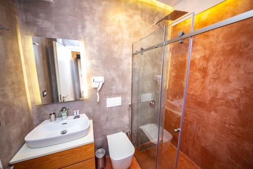 a bathroom with a shower and a sink and a toilet at Inada Hotel Ksamil in Ksamil