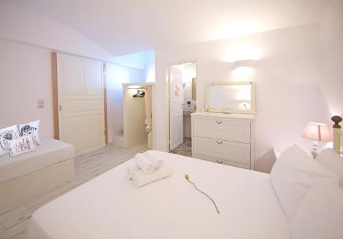 a white bedroom with a bed and a mirror at Villa Katapoliani No.3 in Katapola