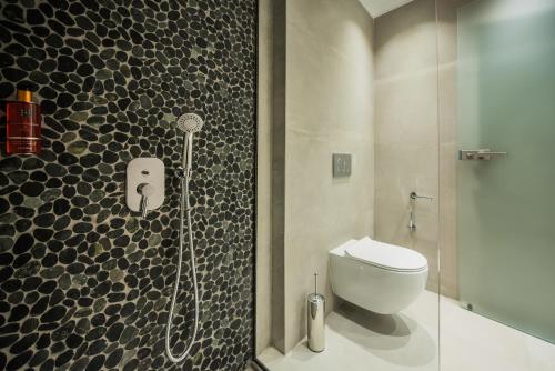 a bathroom with a toilet and a glass shower at Bohemia Luxury Living in Hanioti