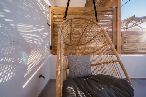 a hammock chair in a room with a window at Bohemia Luxury Living in Hanioti