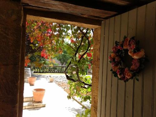 a doorway to a garden with a wreath on a wall at La Lezardiere in Gourdon-en-quercy