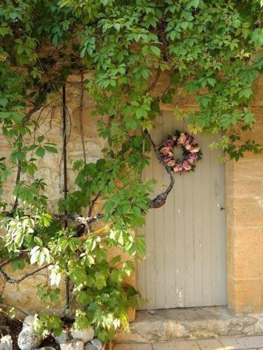 a door with a flower wreath on the side of a building at La Lezardiere in Gourdon-en-quercy