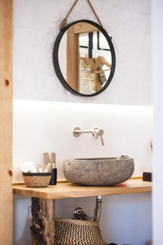 a bathroom with a stone sink and a mirror at Bohemia Luxury Living in Hanioti