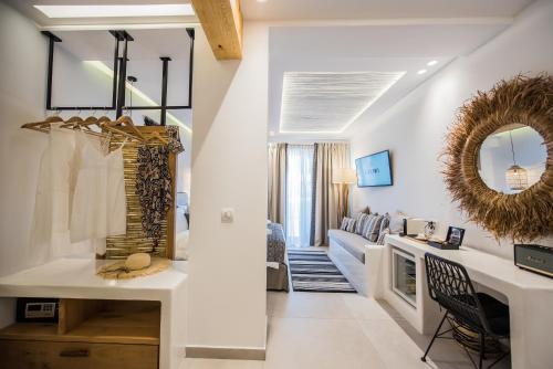 a living room with white walls and a mirror at Bohemia Luxury Living in Hanioti