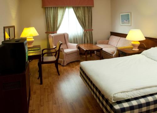 a hotel room with a bed and a living room at Best Western Hotel Scheele in Köping