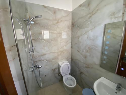 a bathroom with a shower and a toilet and a sink at Guest House Lionel in Durrës