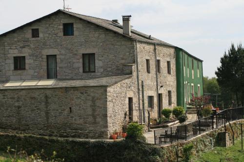 an old stone building with a green roof at Casa Morgade in Sarria