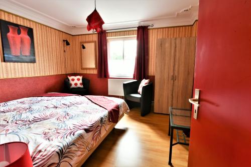 1 dormitorio con 1 cama, 1 silla y 1 ventana en Um die Ecke, en Manderscheid