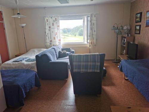 1 dormitorio con sofá, cama y ventana en Wanha Havon Koulu yksiö en Savitaipale