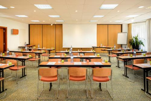 a classroom with tables and chairs and a whiteboard at Novotel Porto Gaia in Vila Nova de Gaia