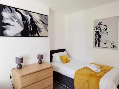 a bedroom with two beds and a painting on the wall at Perry Road, beautiful large house available for Guests and Contractors Parking wifi in Nottingham