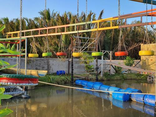 a swing bridge over the water at a water park at Du lịch Hạ Thảo Bến Tre in Ben Tre