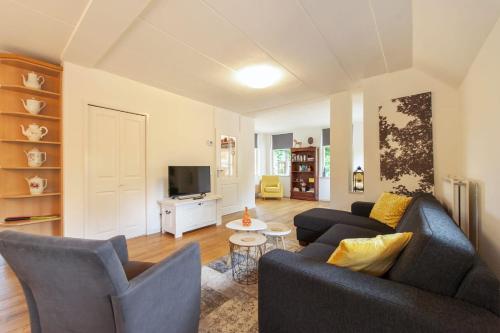 a living room with two couches and a tv at Vakantiehuis Villa 32 in Heel
