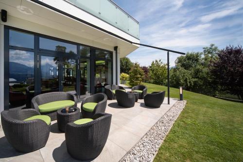 a row of chairs on a patio with grass at Seehof Innsbruck in Innsbruck