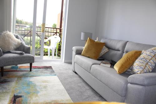 a living room with a couch and a chair at Riverside Apartment in Ayr