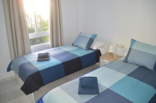 1 dormitorio con 2 camas y ventana en VIVE BENALMÁDENA Apartamento Tranquilo a 400 metros de la PLAYA, en Benalmádena