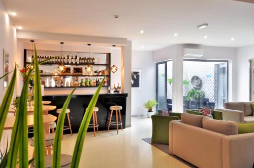 una sala de estar con un bar y algunas plantas en Porto Domus Hotel en Oporto