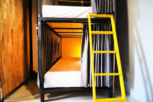 a bunk bed with a yellow ladder in a room at Room 22 in Bangkok