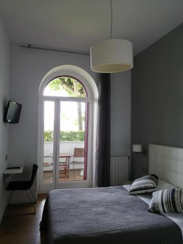 a bedroom with a bed and a window with a table at CR Luarri in Donostia-San Sebastián