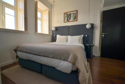 a bedroom with a large bed with white pillows at O Paço - exclusive accommodation in Tomar
