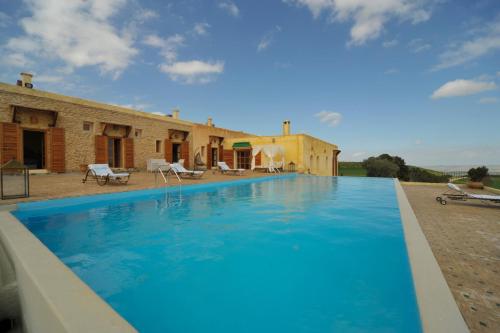 a large swimming pool in front of a house at Terre De Traces Ecolodge in Sefrou