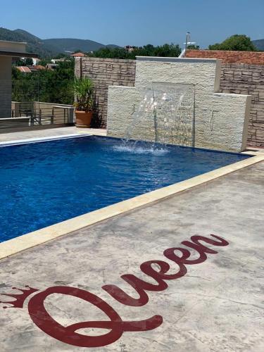 a swimming pool with a stop sign in front of a house at Queen Kodre Apartments in Ulcinj