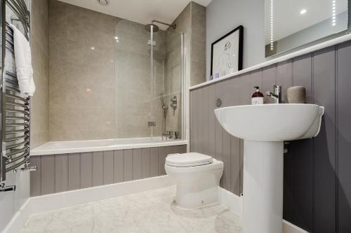 a bathroom with a sink and a toilet and a shower at Tailored Stays - Lovell Lodge in Cambridge