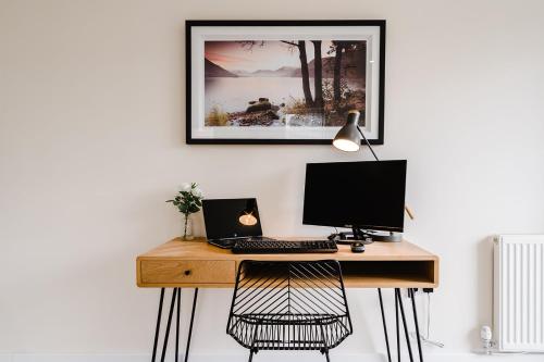 a desk with a computer and a laptop on it at Tailored Stays - Lovell Lodge in Cambridge