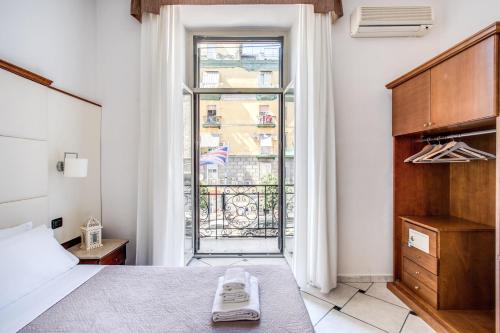 a bedroom with a bed and a large window at Hotel Garibaldi in Naples