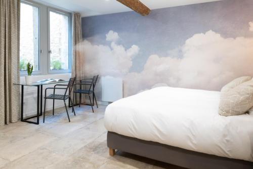 a bedroom with a bed and a table with chairs at Design & Cosy - Centre historique Ecusson in Montpellier