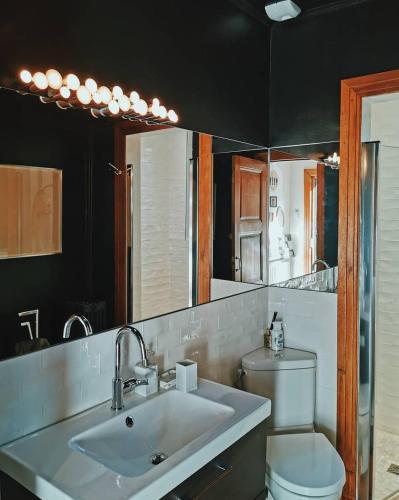 une salle de bain avec un lavabo, des toilettes et un miroir dans l'établissement My Little Roubaix, à Roubaix