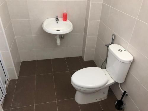 een badkamer met een wit toilet en een wastafel bij DV Villa @ Angsana Sari in Sungai Petani